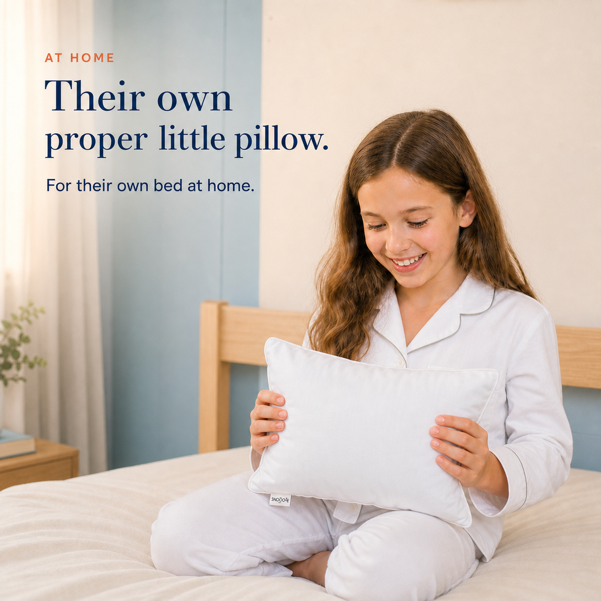 Child holding a Mini Soft Children’s Pillow on her bed at home